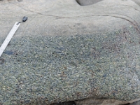 DSC9101 DxO  Premier niveau Ta, au bas de la séquence. Fragments de schistes et de quartzites paléozoïques granoclassés. Les éléments anguleux indiquent un faible transport. Limite de la base très nette.