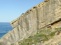 DSC9314 DxO  La limite inférieure du chenal est marquée par un banc qui dessine des hachures verticales. Les sédiments grossiers non stratifiés qui remplissent le chenal contrastent avec le litage régulier des bancs de grès encaissants.